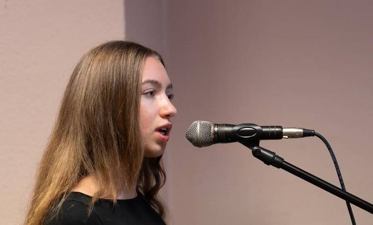 Schülerin singt am Mikrofon